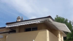 balkon žuta kuća dvije bijelo sive tende